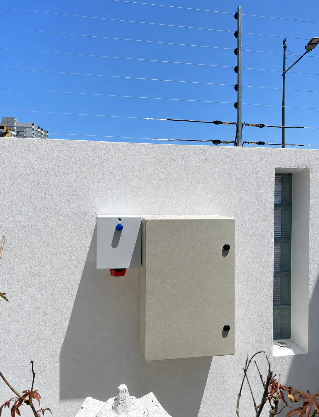 Electric fence energizer enclosure mounted on a clean residential wall