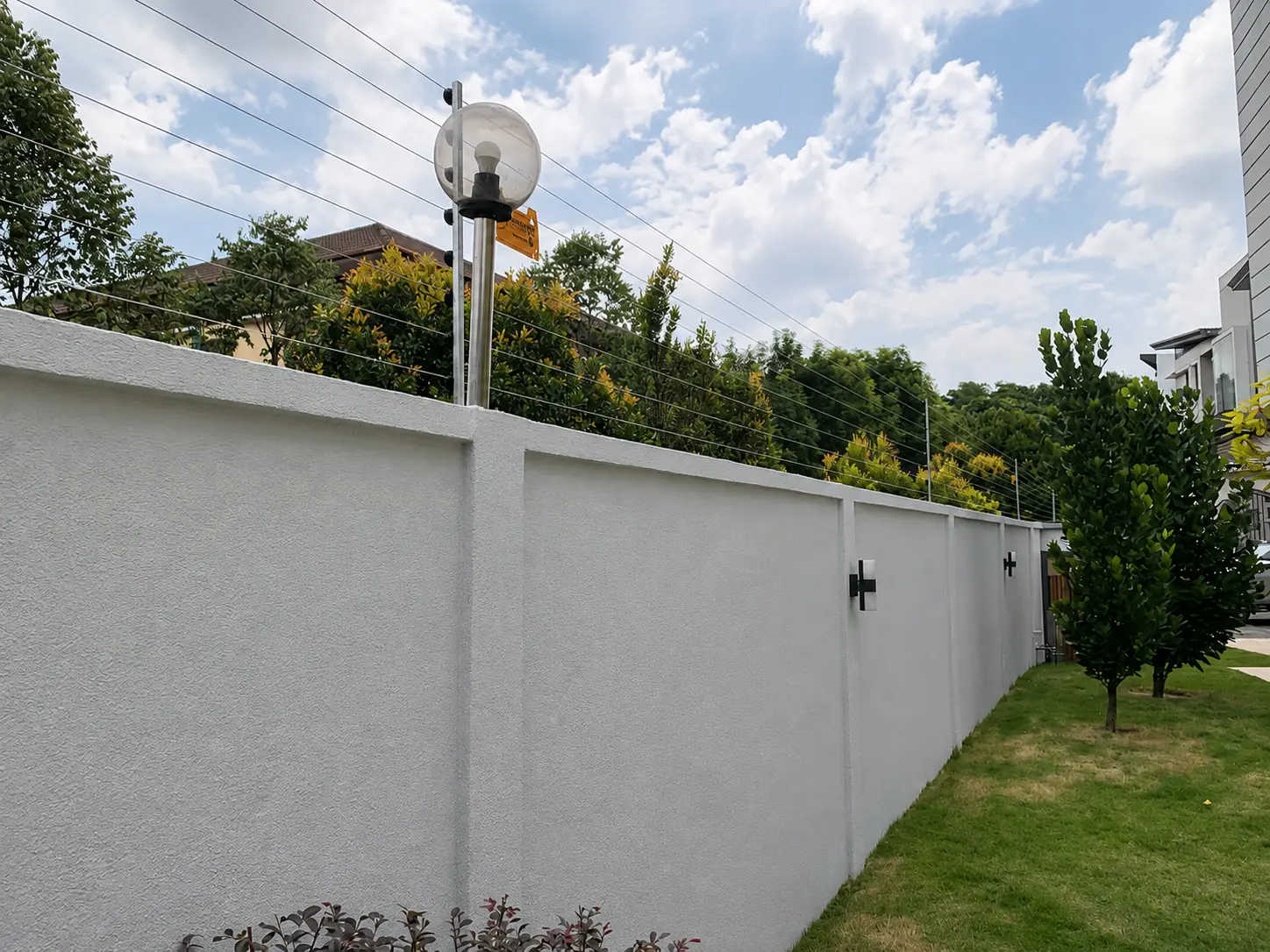 Electric fence installation following a landscaped residential garden wall