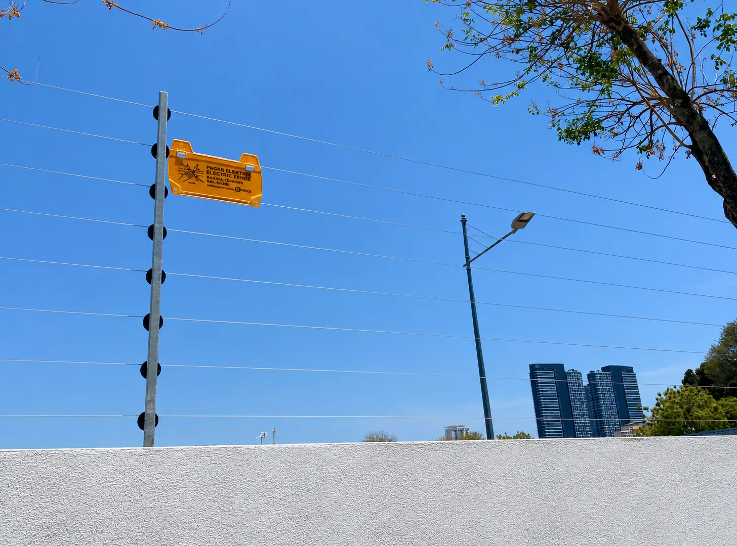 Electric fence warning signage and insulated perimeter wires in an urban setting