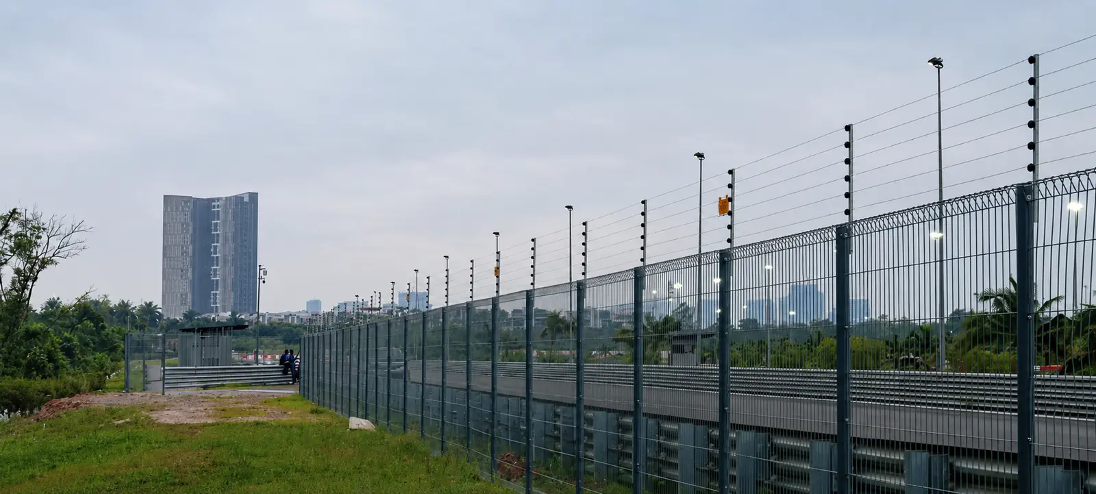 Industrial perimeter electric fence installed along a metal security fence