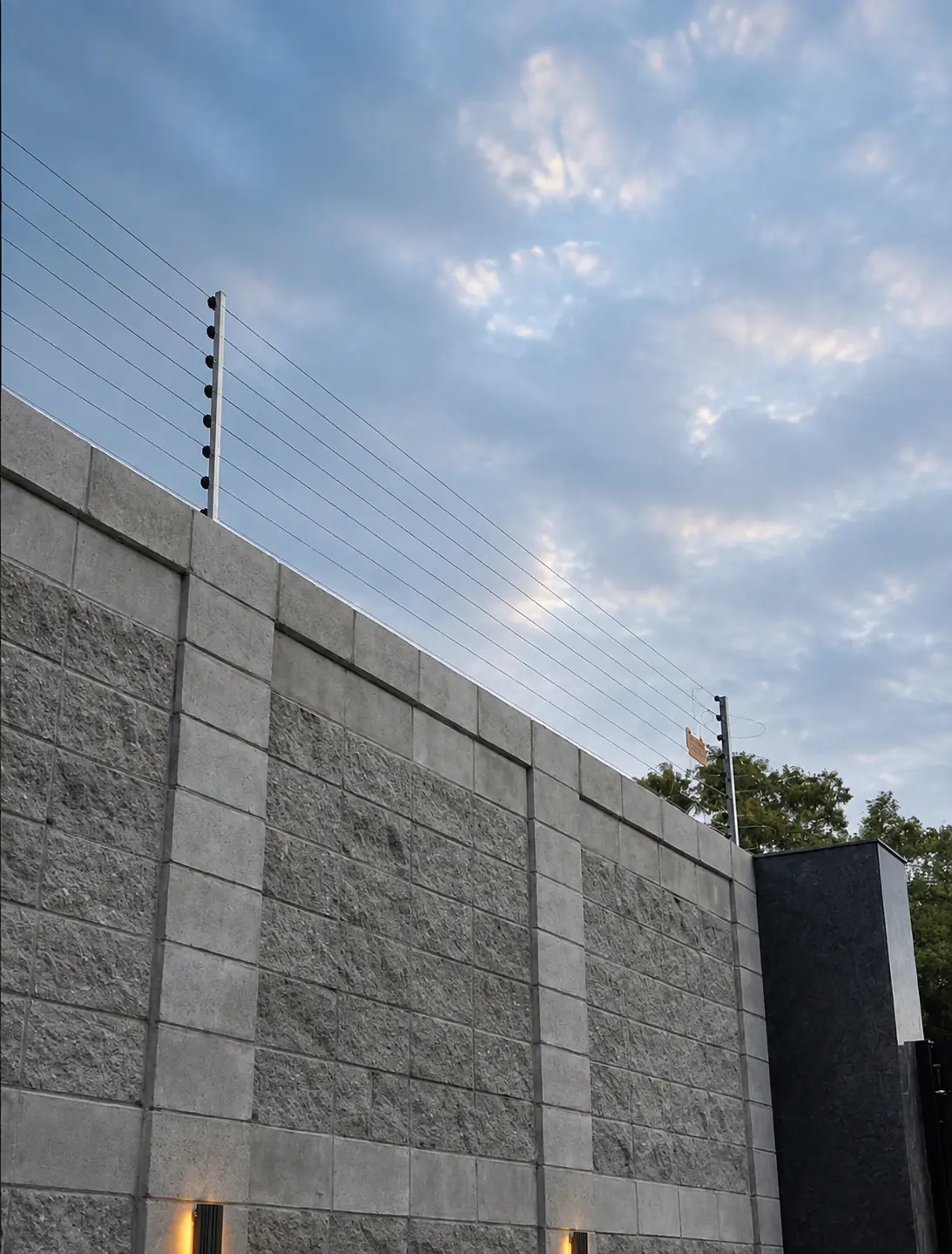 Vertical electric fence posts protecting a high residential boundary wall